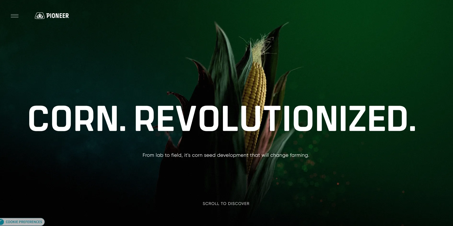 A corn plant with an ear of corn lit by a beam of light against a dark green background, the large white words CORN. REVOLUTIONIZED. across the middle, a line below saying that from lab to field, it is corn seed development that will change farming, and SCROLL TO DISCOVER at the bottom