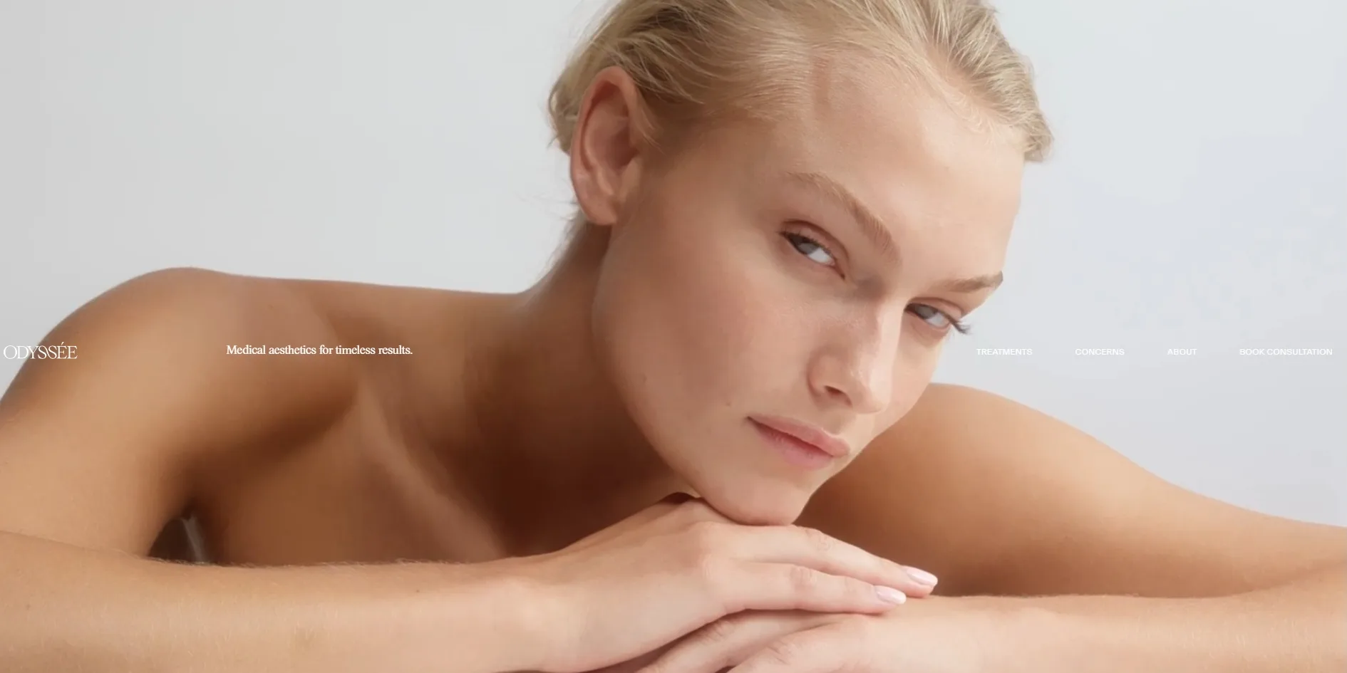 The opening of the home page, with a model resting her chin on her folded hands and the logo, tagline and navigation lined up across the middle of the screen